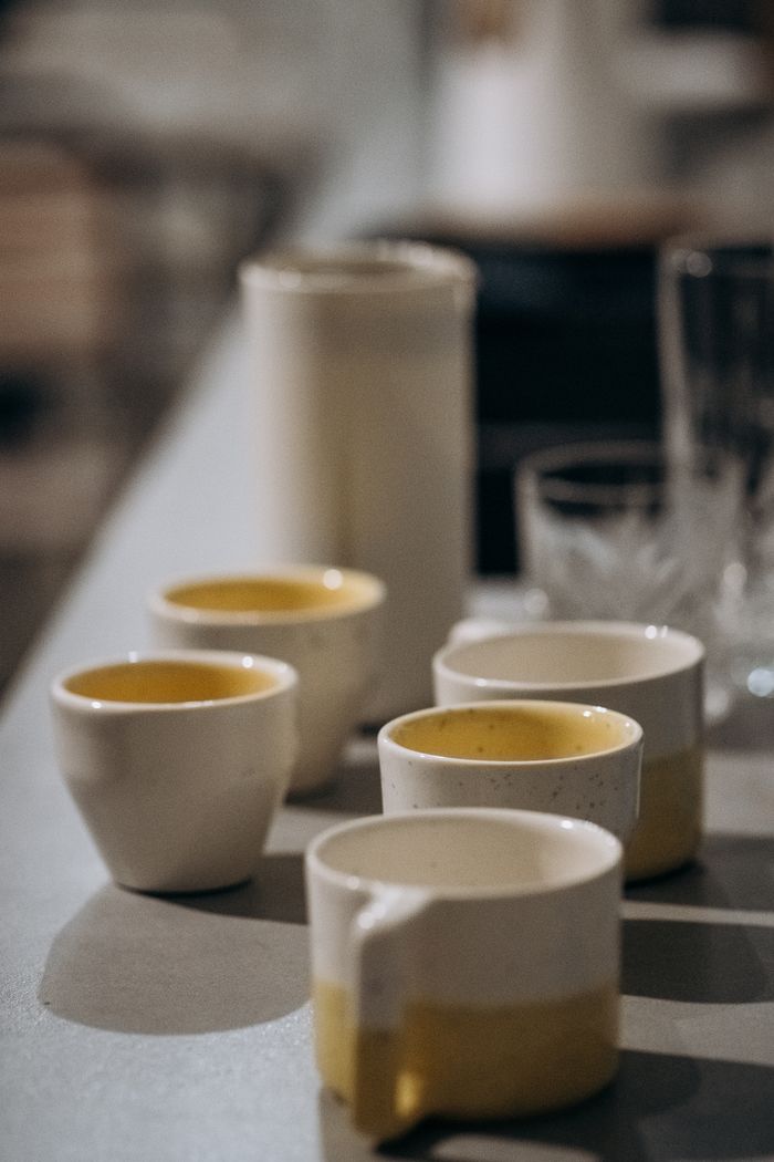 journey-02 A stylish arrangement of ceramic cups and glassware on a modern kitchen counter.