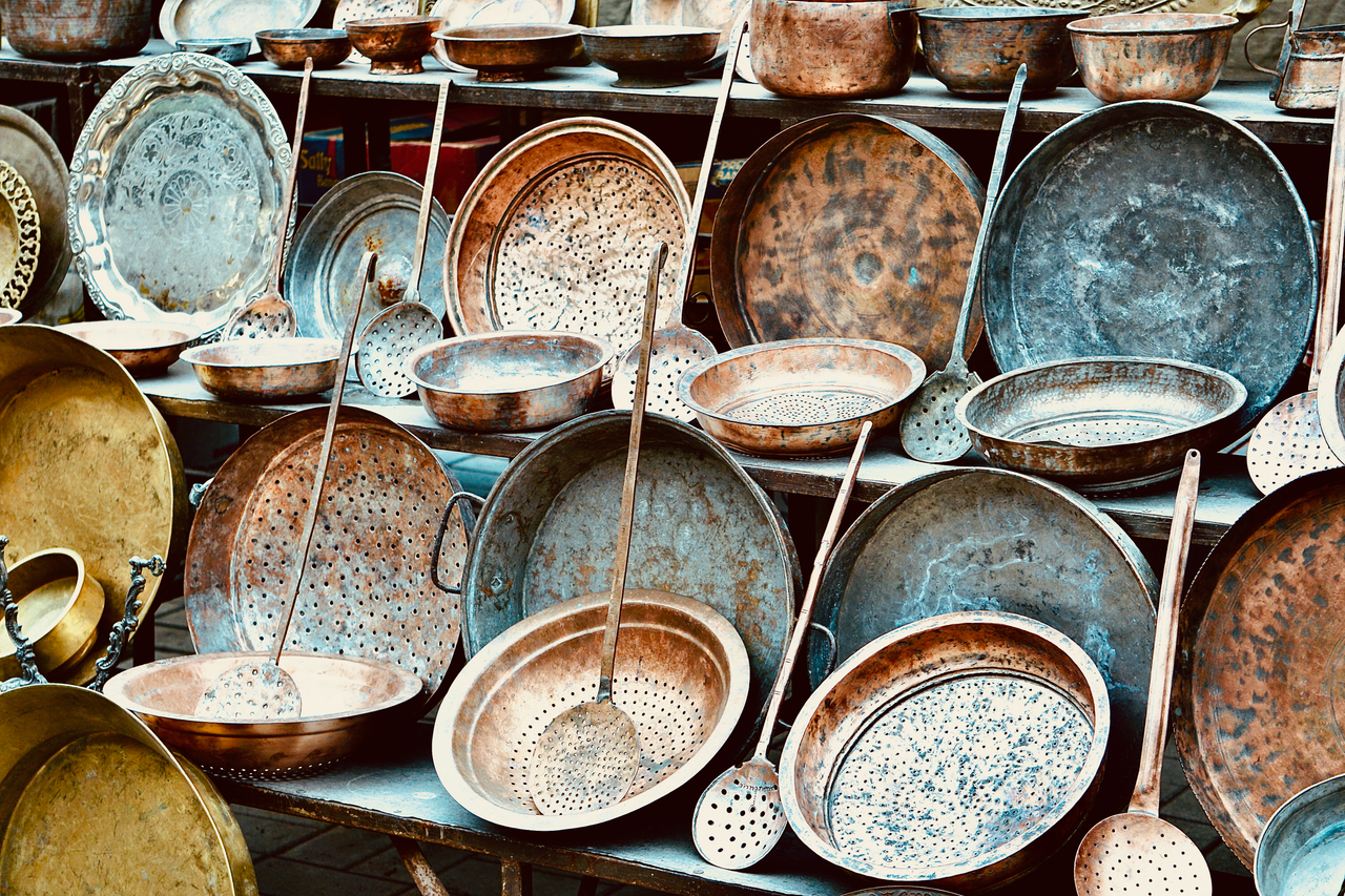 services-01 An assortment of vintage copper kitchenware displayed outdoors, showcasing rustic charm.