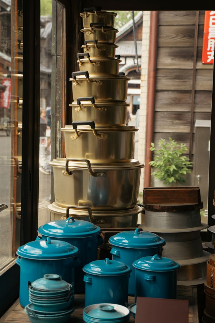 about-img Colorful pots and pans on display in a traditional Tokyo shop window.